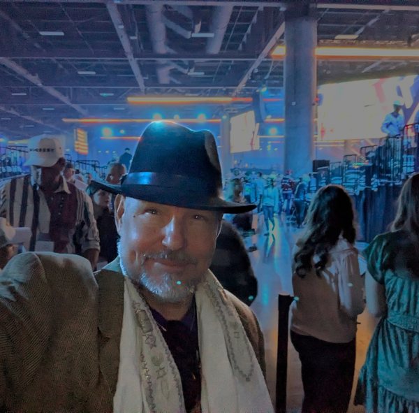 ROCK in a black fedora and prayer shawl at an arena event